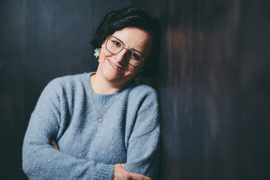 Sonja Sträßer, nachdenklich vor einer dunklen Wand